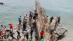 Migrantes cruzan la línea fronteriza.